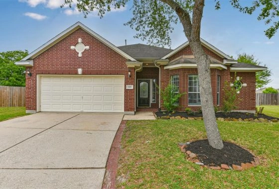 A brick house with a tree in front of it.