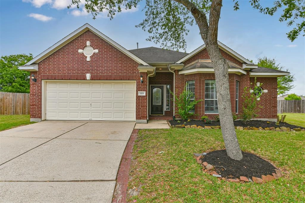 A brick house with a tree in front of it.