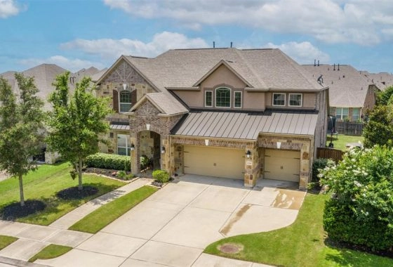 A large house with two garage doors and a driveway.