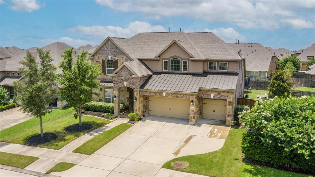 A large house with two garage doors and a driveway.