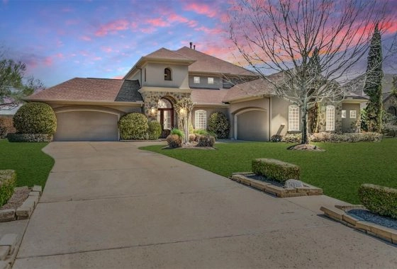 A large house with a driveway and lawn.