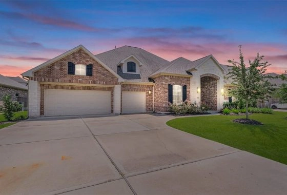 A large brick home with two garage doors.