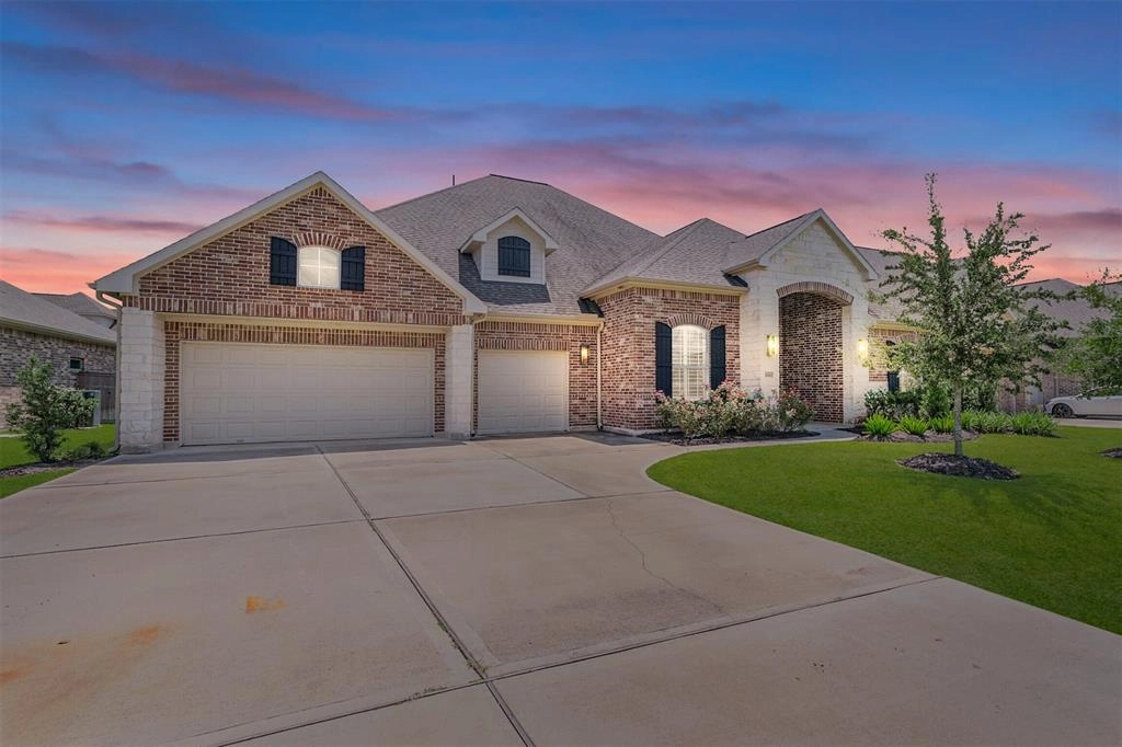 A large brick home with two garage doors.