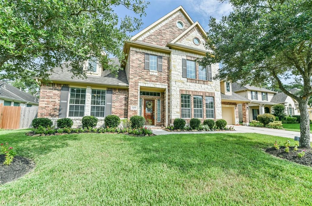 A large brick home with green grass in front of it.