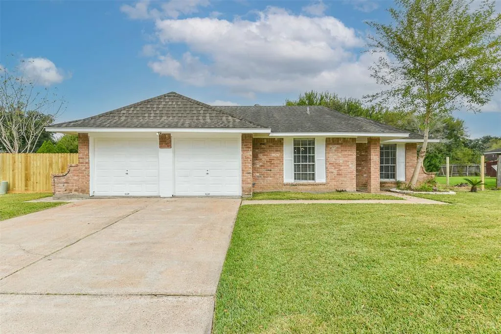 A house with two garage doors and grass in front of it.