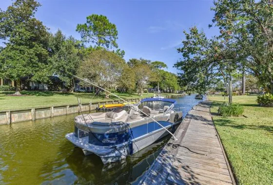 A boat is docked on the water near some trees.