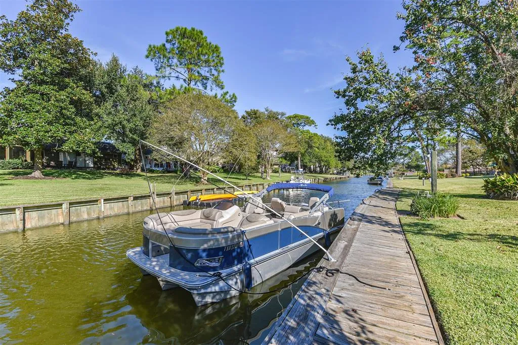 A boat is docked on the water near some trees.