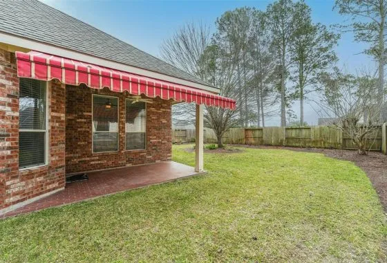 A house with a red and white awning on the side of it.