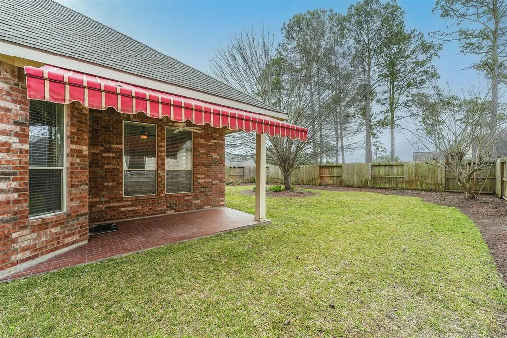 A house with a red and white awning on the side of it.