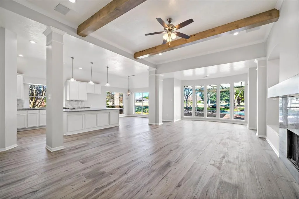 A large open floor plan with white walls and wood floors.