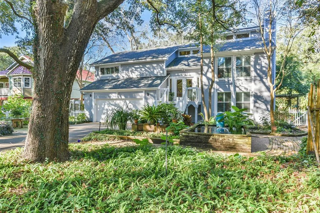 A large white house with a tree in the front yard.