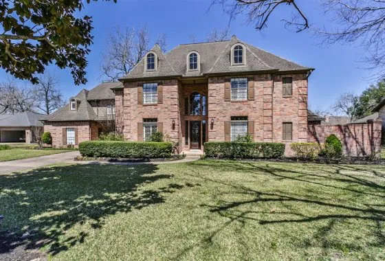 A large brick house with trees in the background.