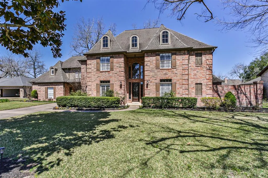 A large brick house with trees in the background.