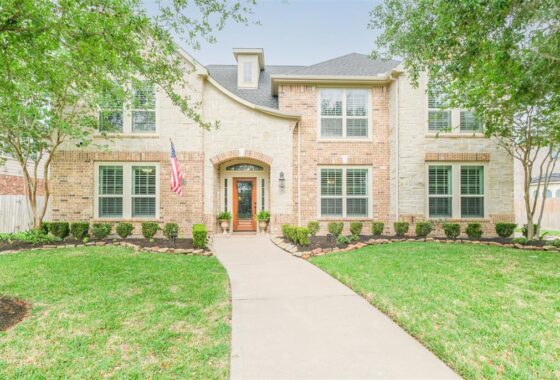 A large brick home with american flag on the front.