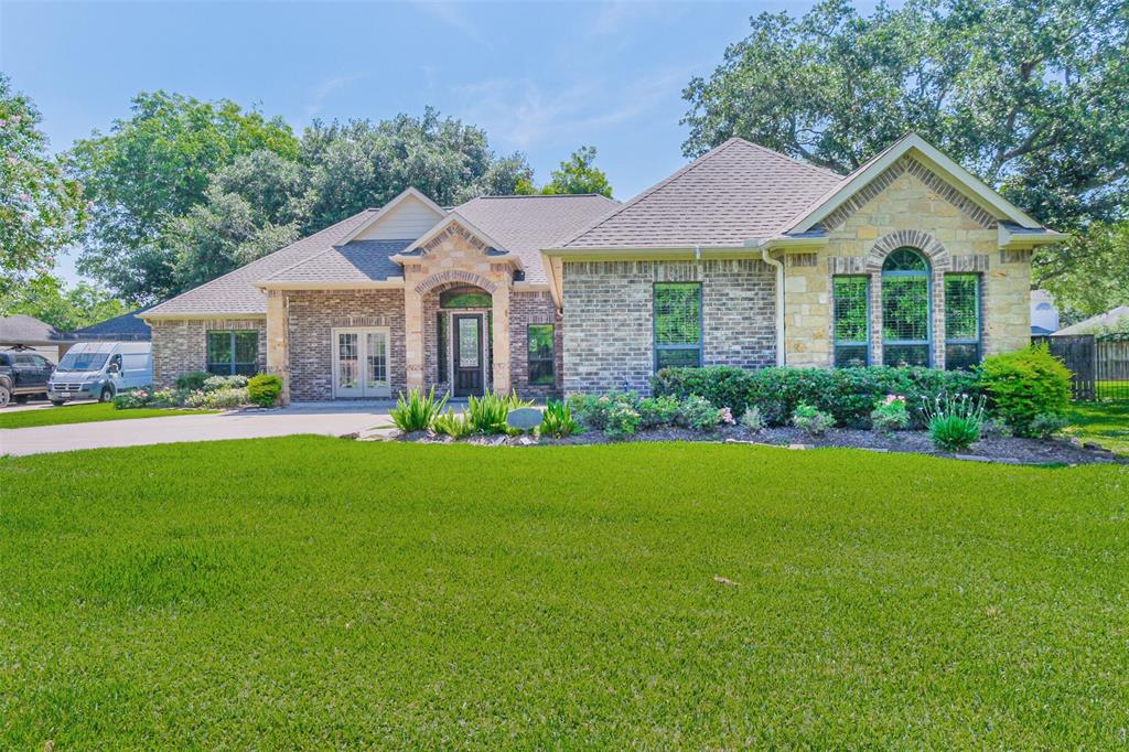 A large brick home with green grass in front of it.