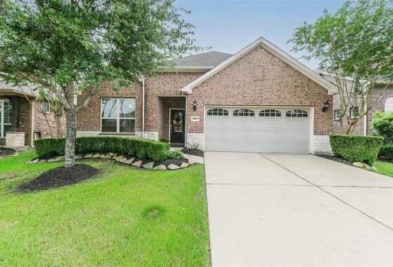 A large brick home with a driveway and landscaping.
