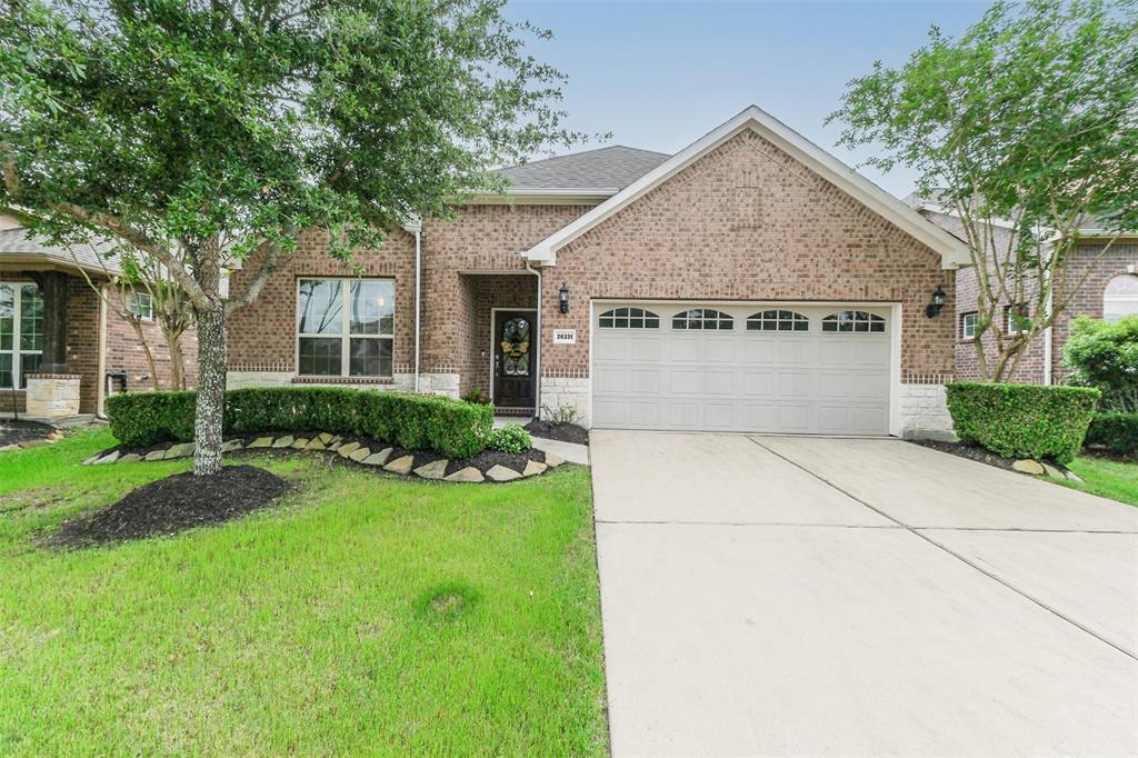 A large brick home with a driveway and landscaping.