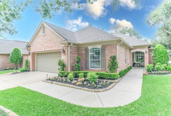 A large brick home with a driveway and landscaping.
