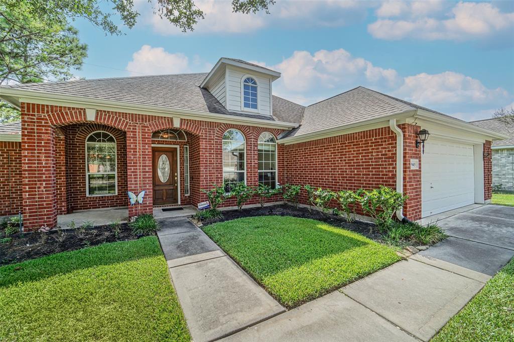 A brick house with grass in front of it.