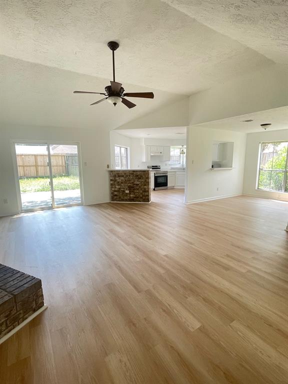 A large open living room with hard wood floors.
