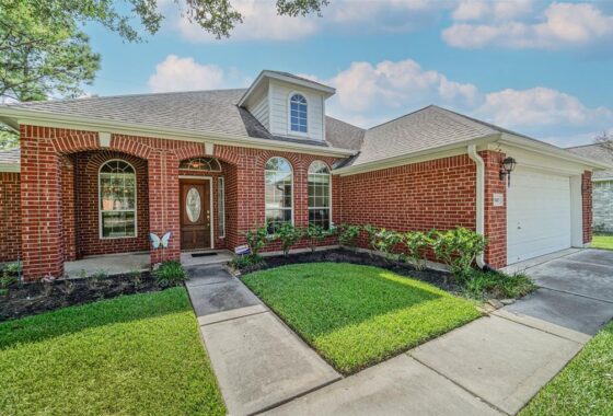 A brick house with grass in front of it.