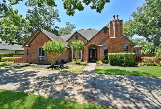 A large brick house with trees in the background.