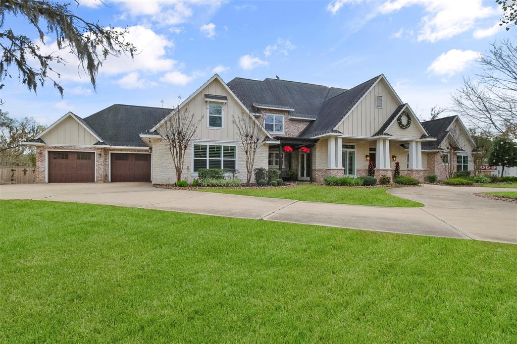 A large white house with a driveway and lawn.