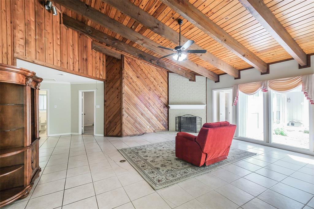 A living room with tile floors and wood walls.
