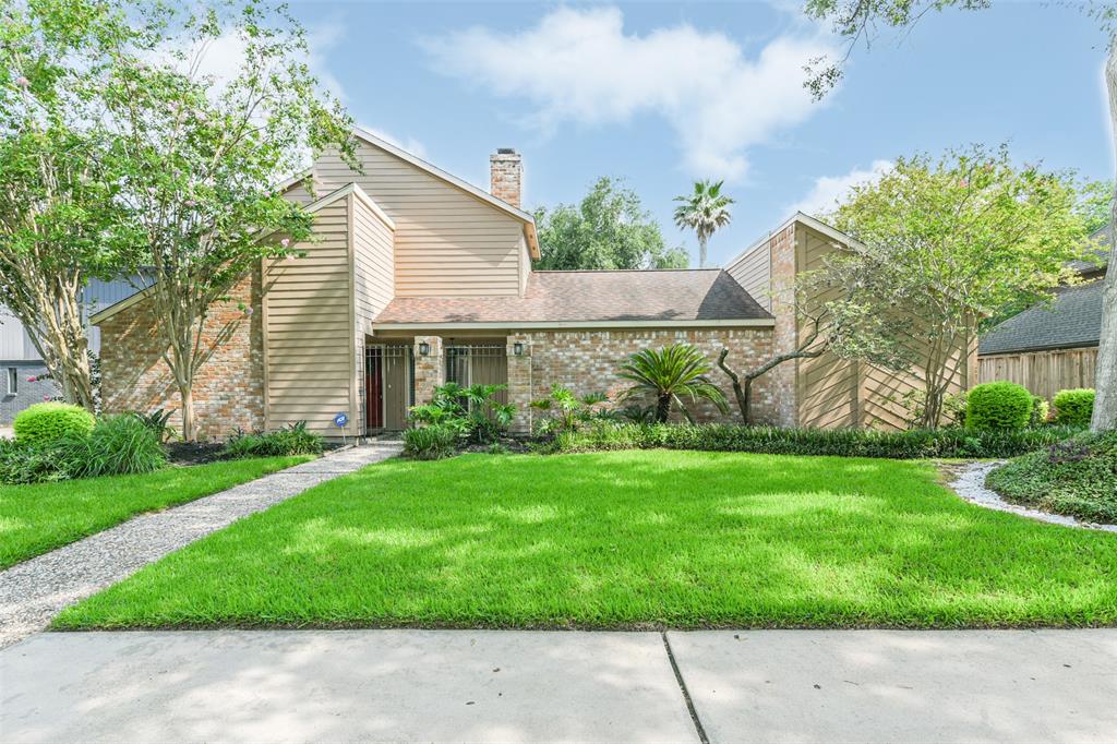 A house with grass and trees in front of it.