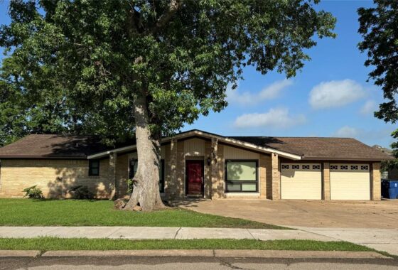 A house with a large tree in front of it.