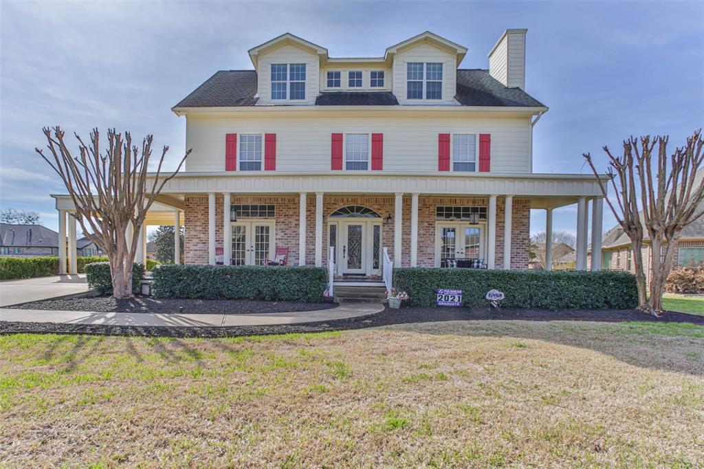 A large white house with red shutters and a porch.