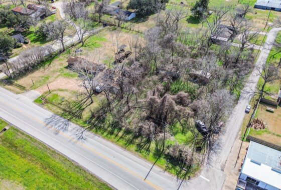 An aerial view of a road with trees in the background.